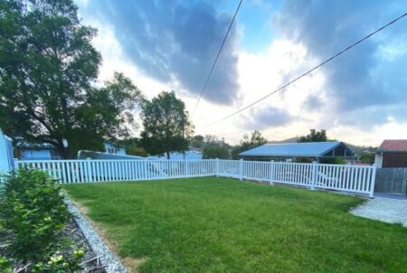 Margaret PVC garden fence gallery enclosing a wide front lawn by Queensland Fencing Specialists