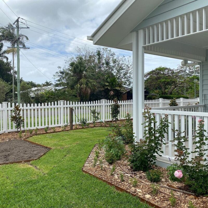 Elizabeth scalloped picket fence gallery in a landscaped front yard by Queensland Fencing Specialists